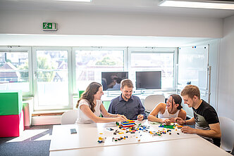 Studierende arbeiten mit Bausteinen