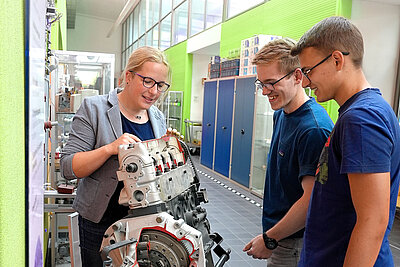 Prof. Dr. Anke Müller zeigt zwei Studierenden Technik in der Maschinenhalle