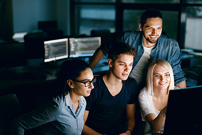 Group of young students sitting in front of a computer