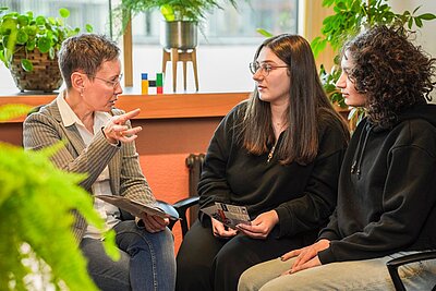 Beratungssituation in einem Büro mit einer Professorin und zwei Studentinnen