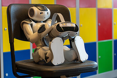 Roboter NAO sitzt auf einem Stuhl