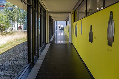 Blick in den Gang der Hochschule Hof zwischen Gebäude A und B, Studierende laufen im Gang